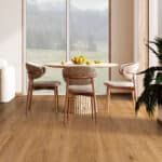Bright dining nook with round table, woven chairs, and large windows overlooking a foggy view