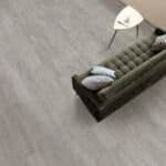 Top-down view of a gray sofa with a white lamp beside it on a light wood floor