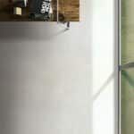 Blurred indoor scene with a white wall, wooden cabinet, and green-trimmed window.