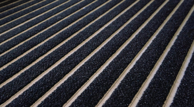 Close-up of dark ribbed mat with diagonal white stripes