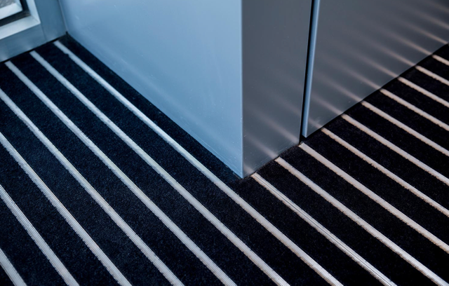 Modern stairwell with black steps and white stripes beside a glass wall