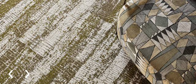 Geometric patterned rug in beige, gray, and brown on a textured floor surface