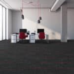 Modern lounge with two red chairs, white tables, and large windows in a minimalist room