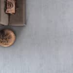 Top-left corner of a tabletop with a small wooden container and a round bowl on a gray surface