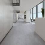Bright modern hallway with white walls, glass windows, and light gray flooring