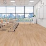 Empty classroom with desks, whiteboard, and large windows overlooking a city skyline
