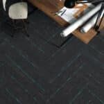 Dark herringbone floor with a chair leg and a wooden table edge in the corner