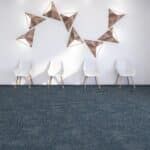 White chairs under gold star decorations against a white wall with a dark blue carpet below