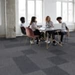 Four people sit around a table in a bright office meeting room.