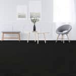 Minimal white living room with wooden bench, side table, flowers, and gray chair on black floor mat