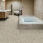 Indoor bathroom with beige tile floor and a built-in white step-in tub or spa on the right.