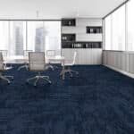 Modern conference room with white chairs, built-in cabinets, and dark blue carpet, seen through large windows