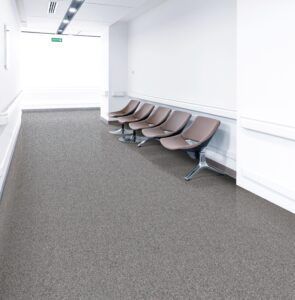 Empty hallway with a row of brown waiting chairs along the right wall