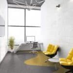 Modern office lounge with yellow chairs, gray sofa, desk, and large windows