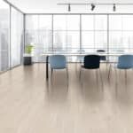Modern conference room with a long table, blue chairs, and bright floor-to-ceiling windows