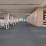 Empty indoor corridor with tables and chairs on the left and bookshelves on the right