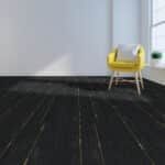 Yellow chair on a dark floor in a bright room near a window.