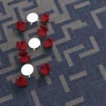 Two red toy chairs on a patterned carpet, with white round tops behind them