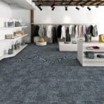 Clothing boutique with racks of garments, shelves, and a dark blue carpeted floor