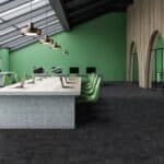 Modern office dining area with a long table, green chairs, and a green accent wall