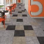 Hallway with orange chairs and a gray-and-black checkered carpet leading to a large orange number 5