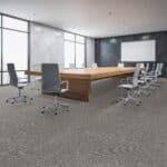 Modern conference room with long wooden table, office chairs, and a projection screen in a bright meeting space