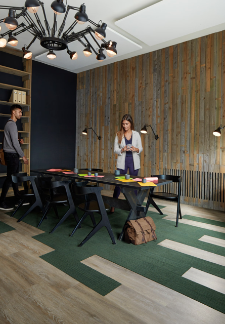 A herringbone pattern wood floor featuring alternating light and medium brown planks with visible wood grain texture.
