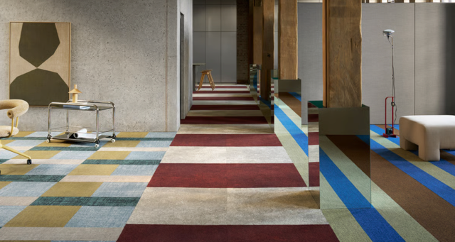 Modern interior with a colorful striped carpet leading through a minimalist room and hallway