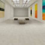 Minimalist gallery with white walls, a closed shutter, and colorful abstract panels on the right wall.