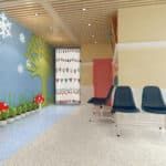 Empty waiting area with blue chairs, a colorful mural, and a patterned doorway.