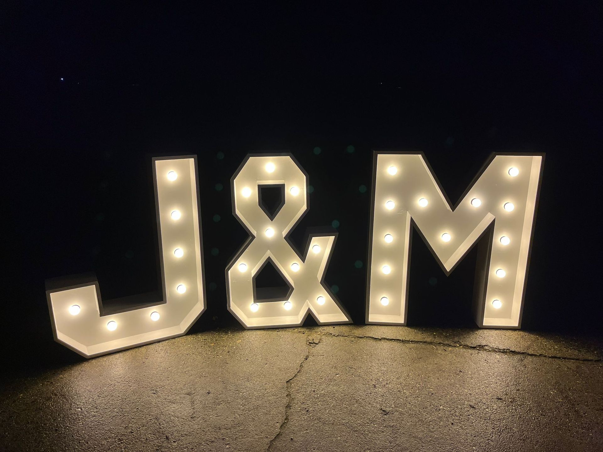 Grote, verlichte letters in de stijl van een lichtreclame, die