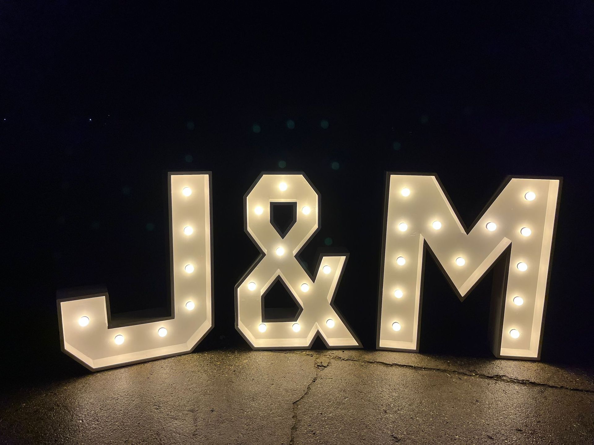 Grote, verlichte letters in de stijl van een lichtreclame, die