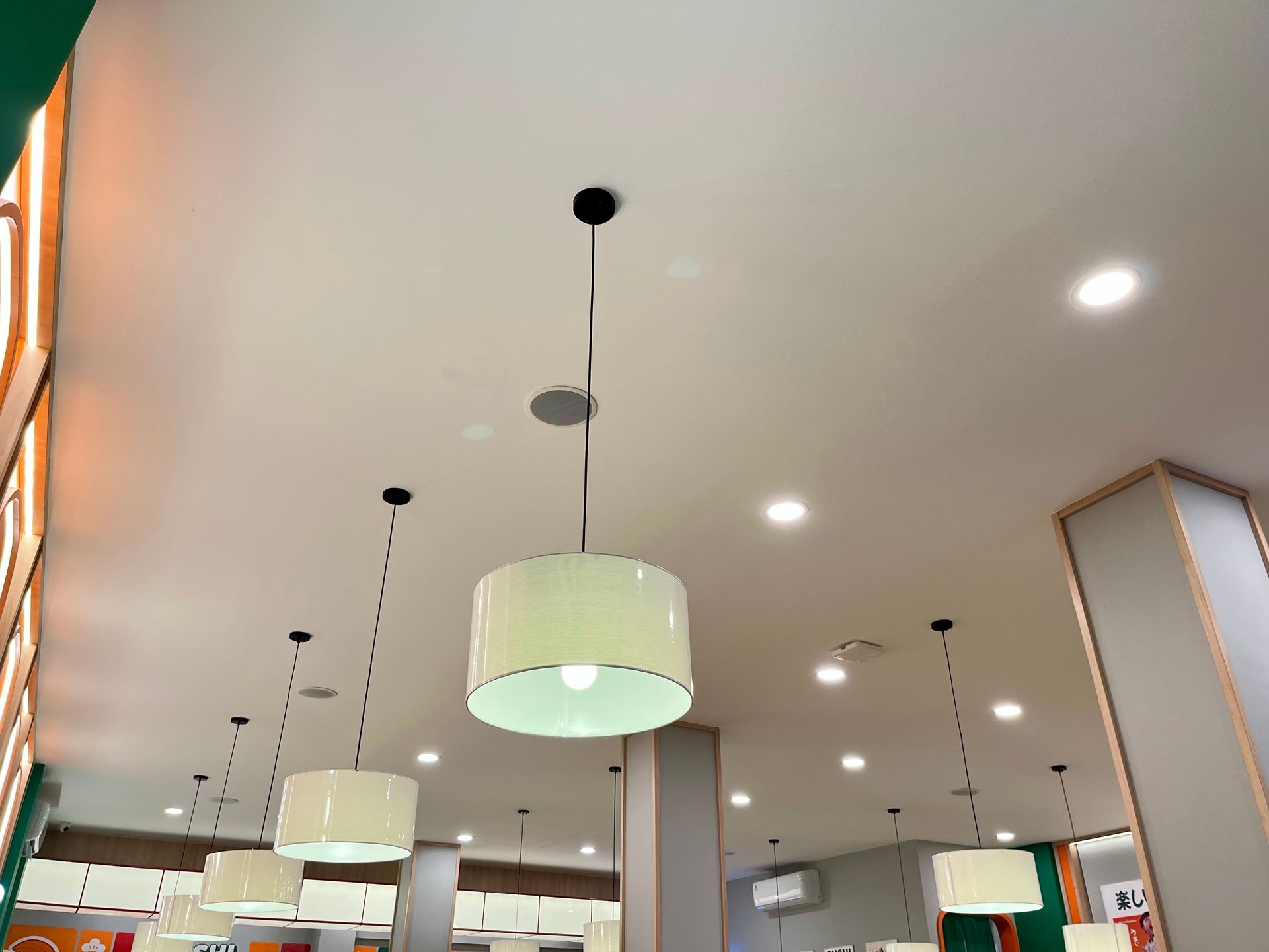 Modern cafe interior with hanging pendant lights and recessed ceiling lights