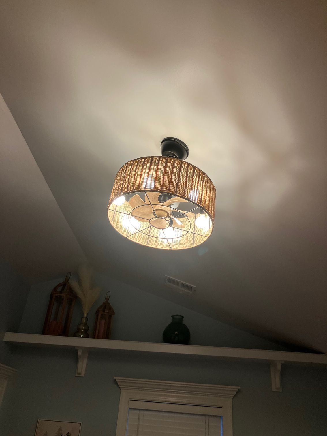 Ceiling fan on exposed wooden rafters inside a rustic roofed interior