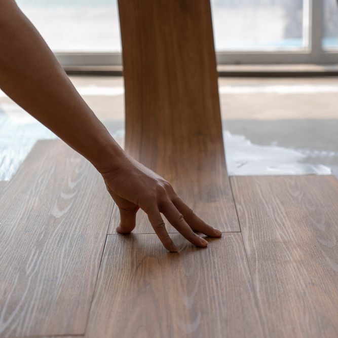 A person 's hand is reaching for a piece of wood