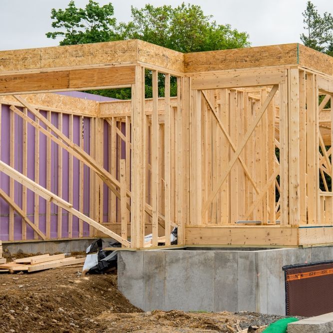 Dywall And Painting Materials A house is being built with wooden frames and purple insulation.
