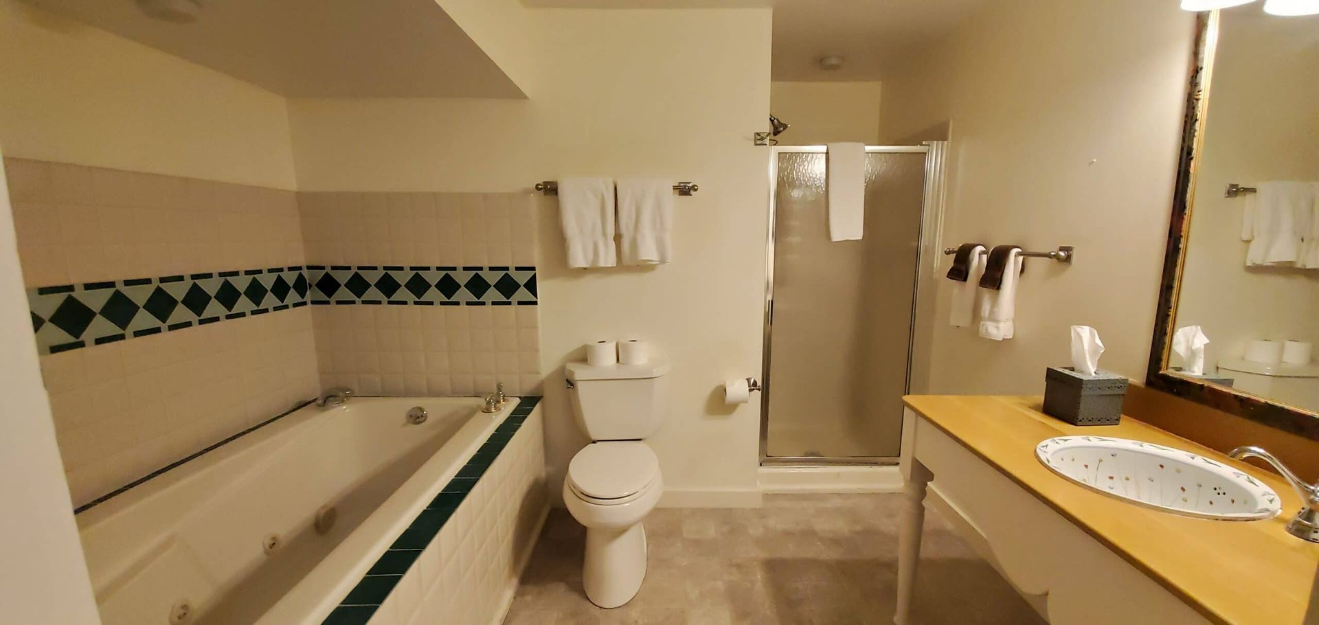 A bathroom with a toilet , sink , tub and shower.