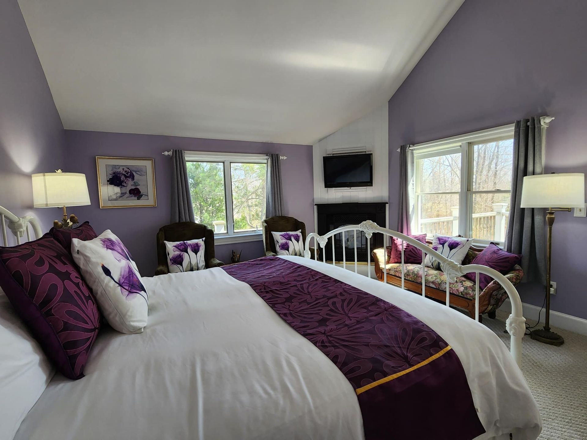 A bedroom with purple walls and a king size bed