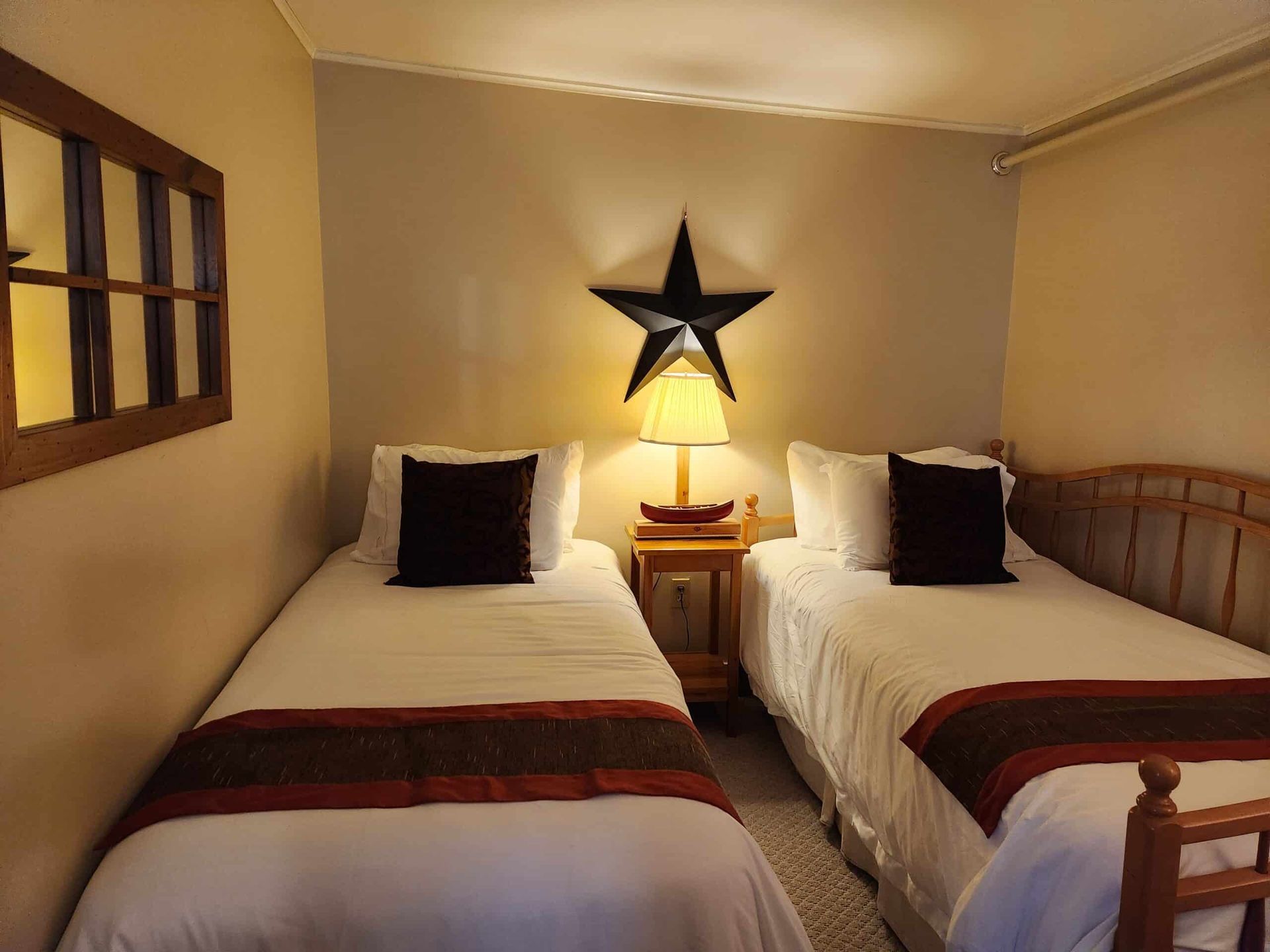 A bedroom with two twin beds and a star on the wall.
