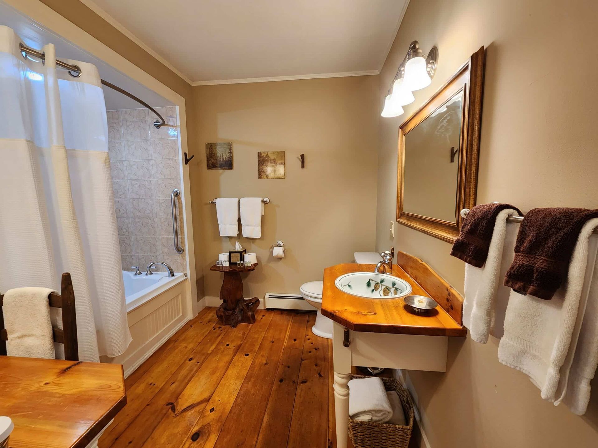 A bathroom with a sink , toilet , tub and mirror