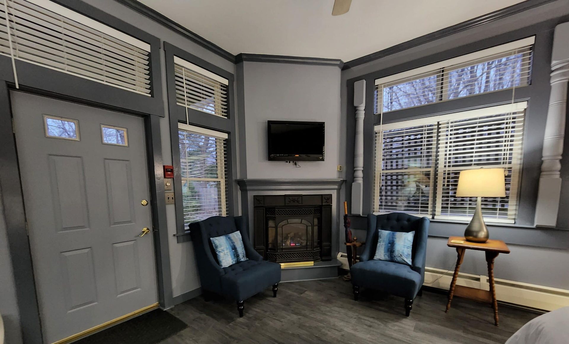A living room with two chairs , a fireplace and a television.