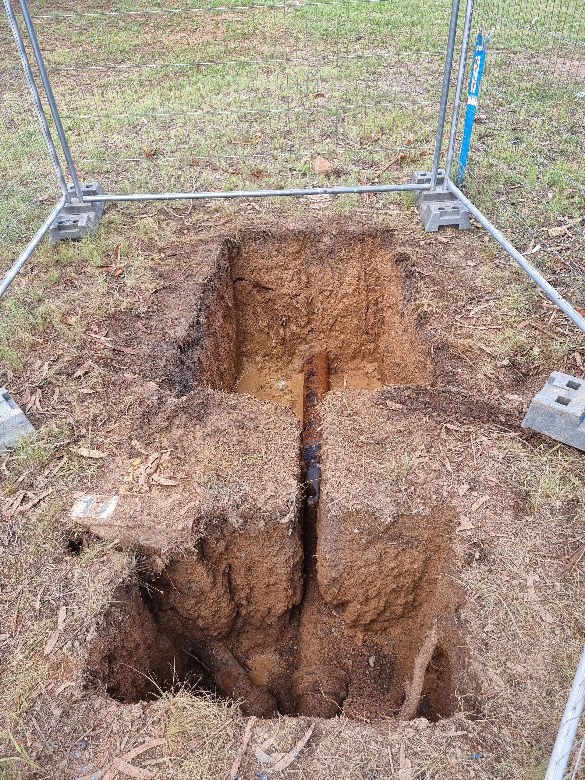 Open rectangular hole in the ground, possibly for a utility. Metal frame around the hole — Pro Pipe Solutions in Queanbeyan, NSW