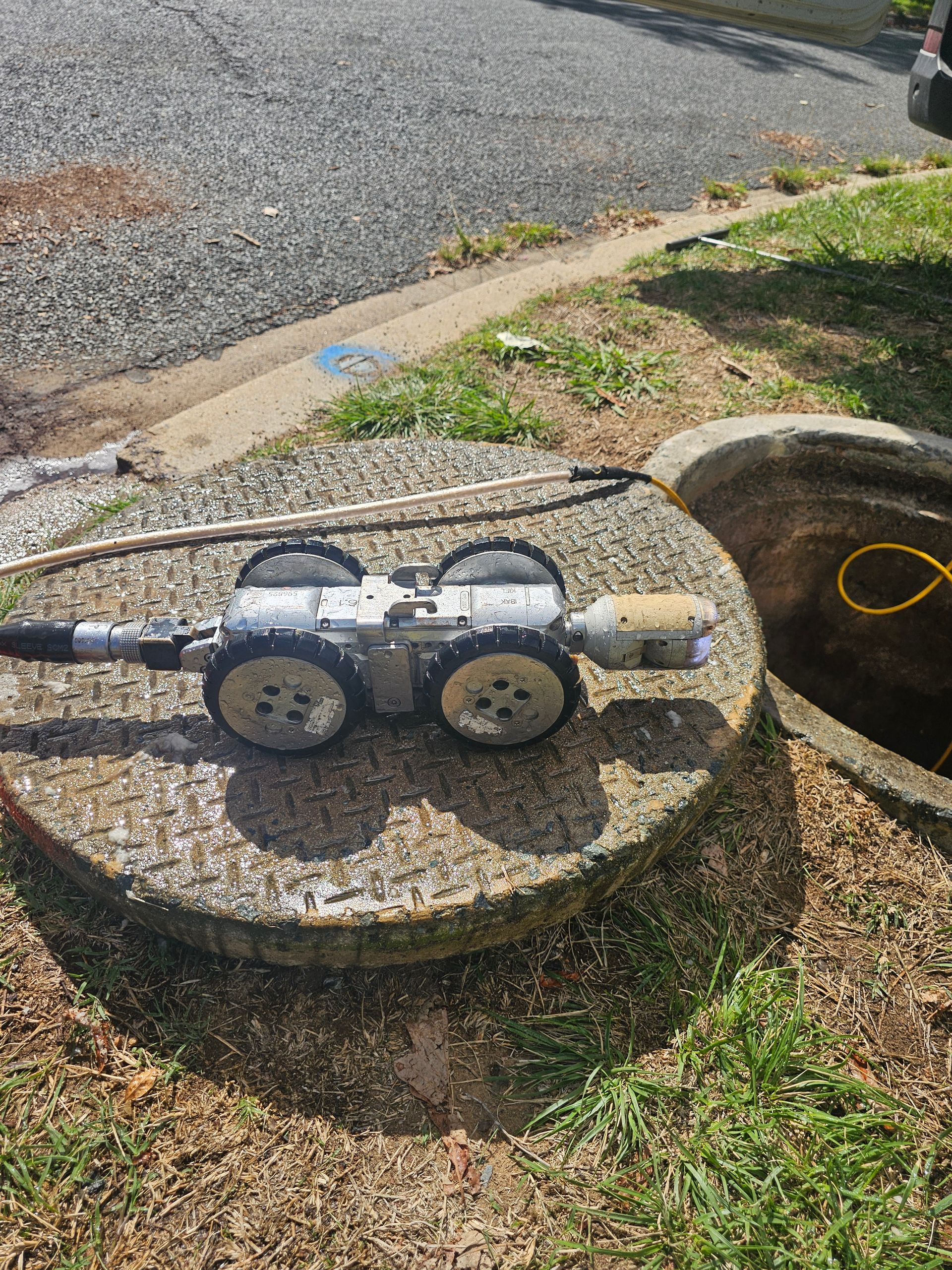 A sewer inspection robot atop a manhole cover, ready to enter the drain — Pro Pipe Solutions in Queanbeyan, NSW
