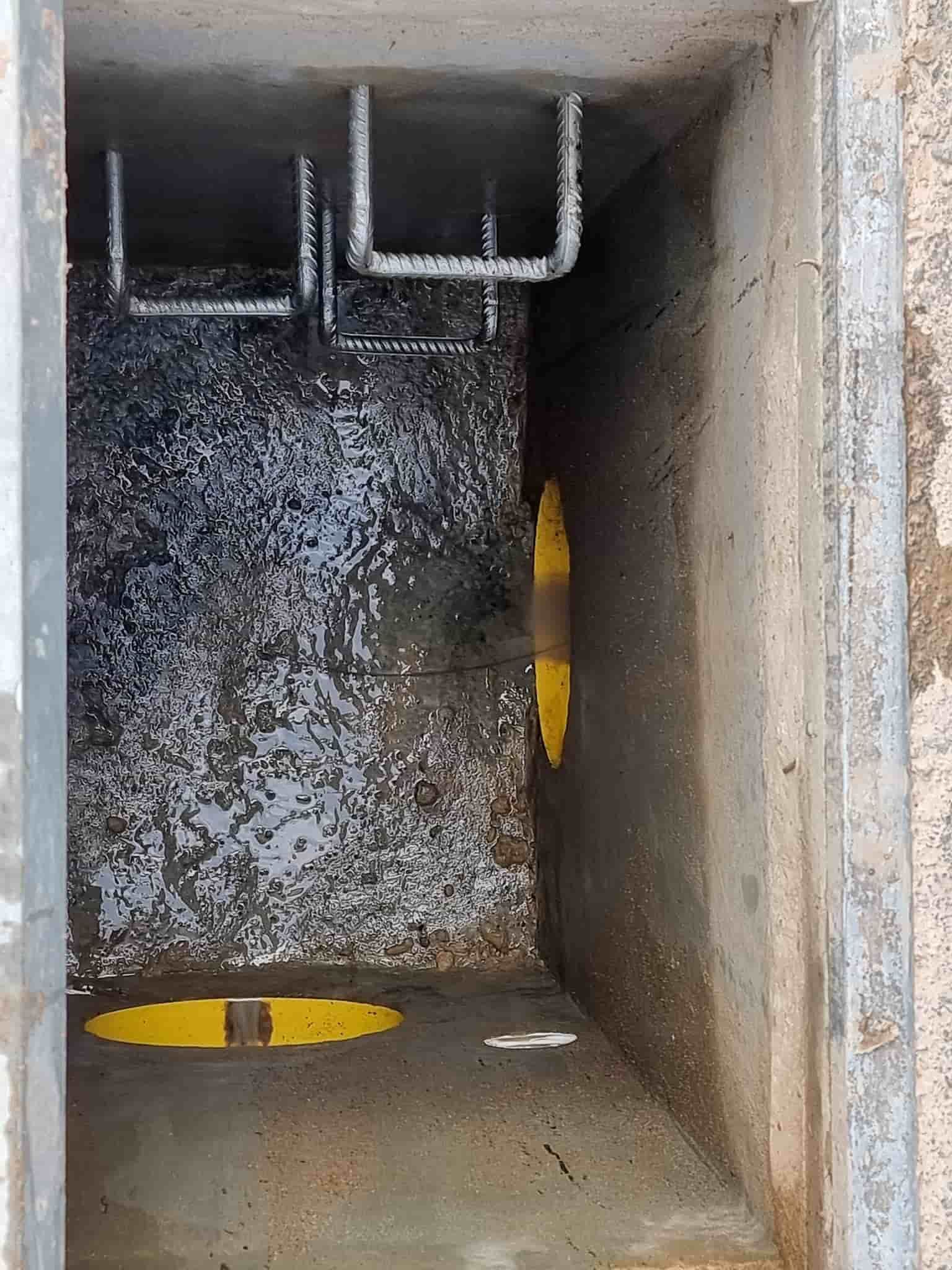 A Concrete Utility Vault Interior, Partially Filled With Water, With Yellow Markings — Pro Pipe Solutions in Queanbeyan, NSW