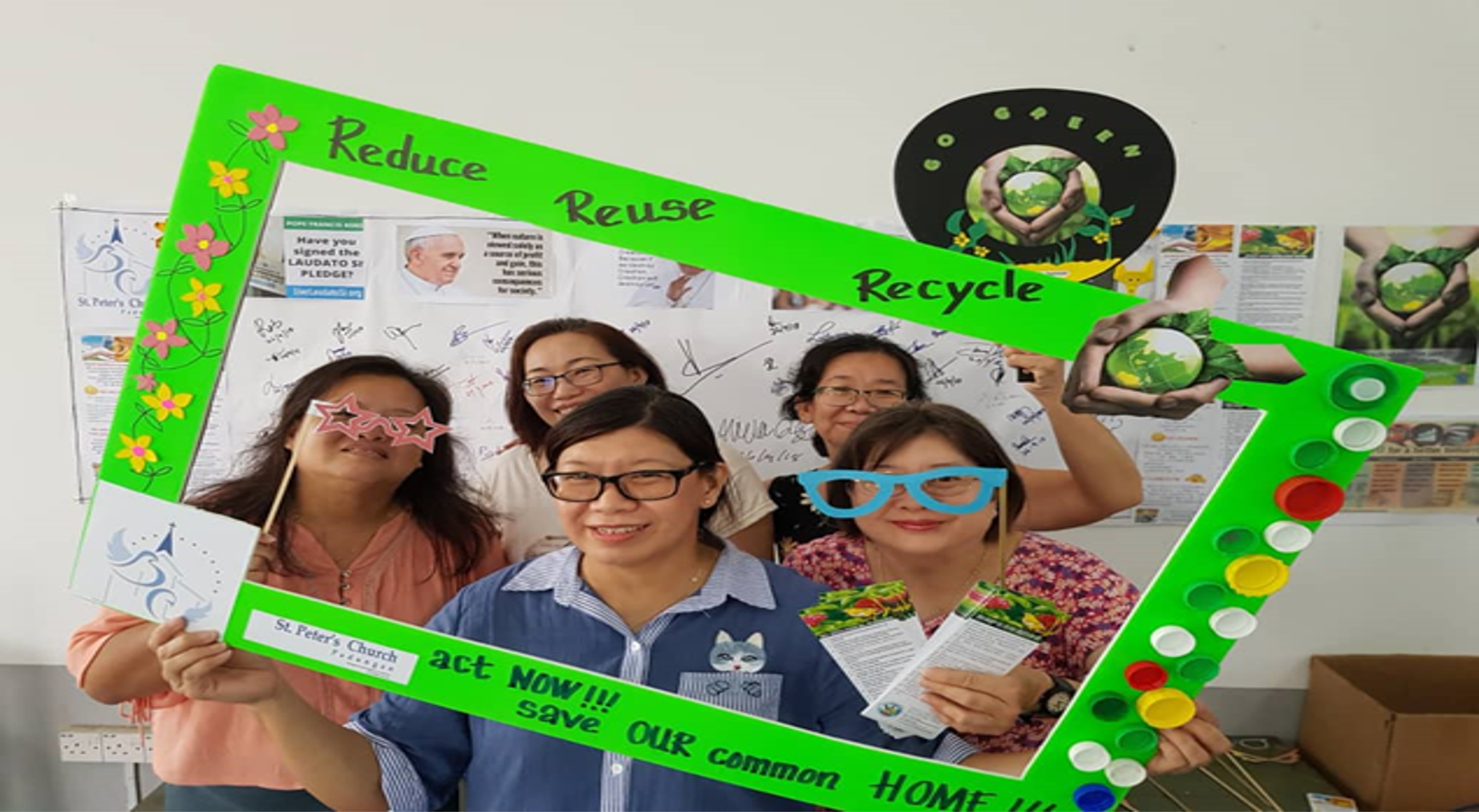 Five women pose with a green