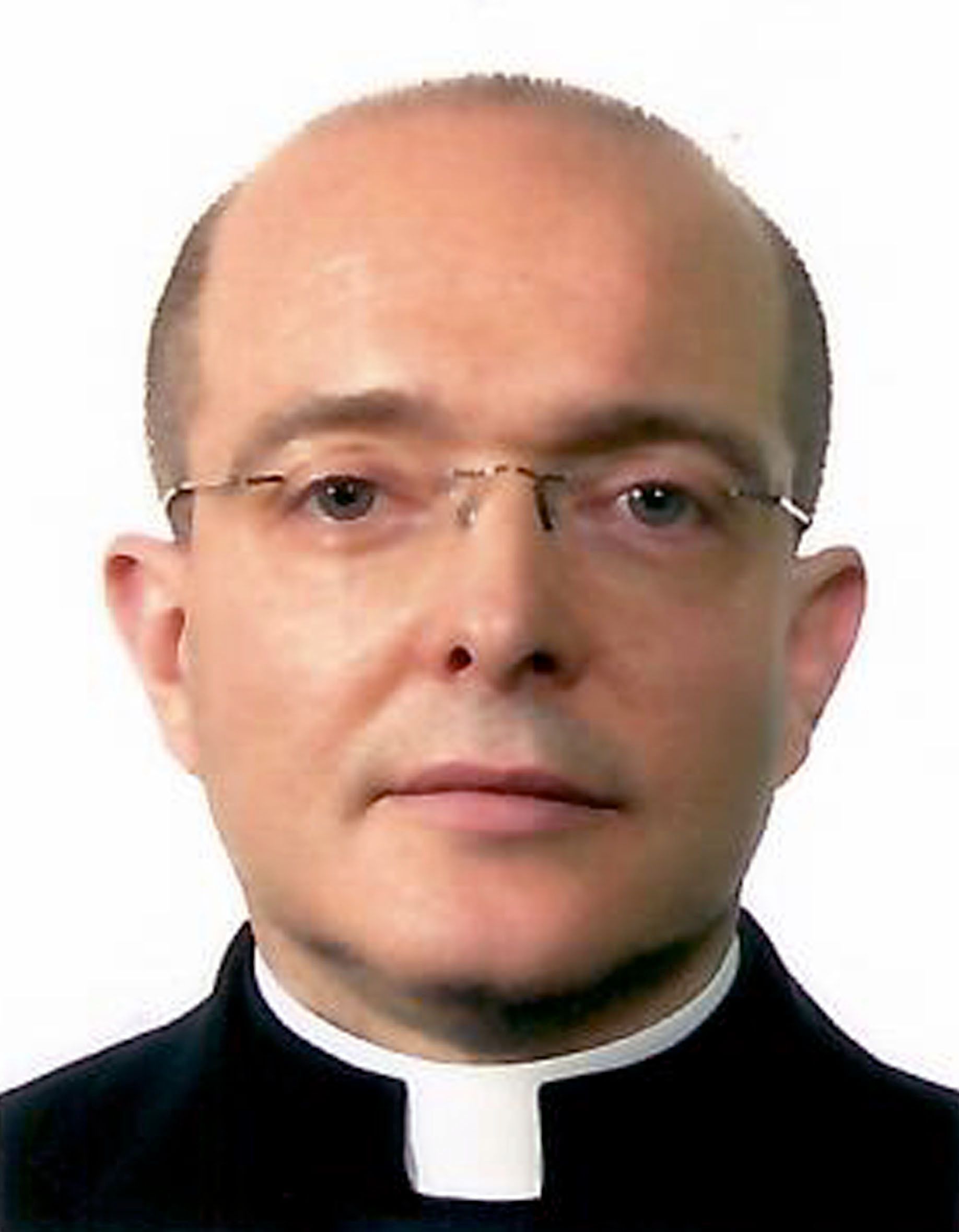 Man with glasses wearing a clerical collar, likely a religious figure.