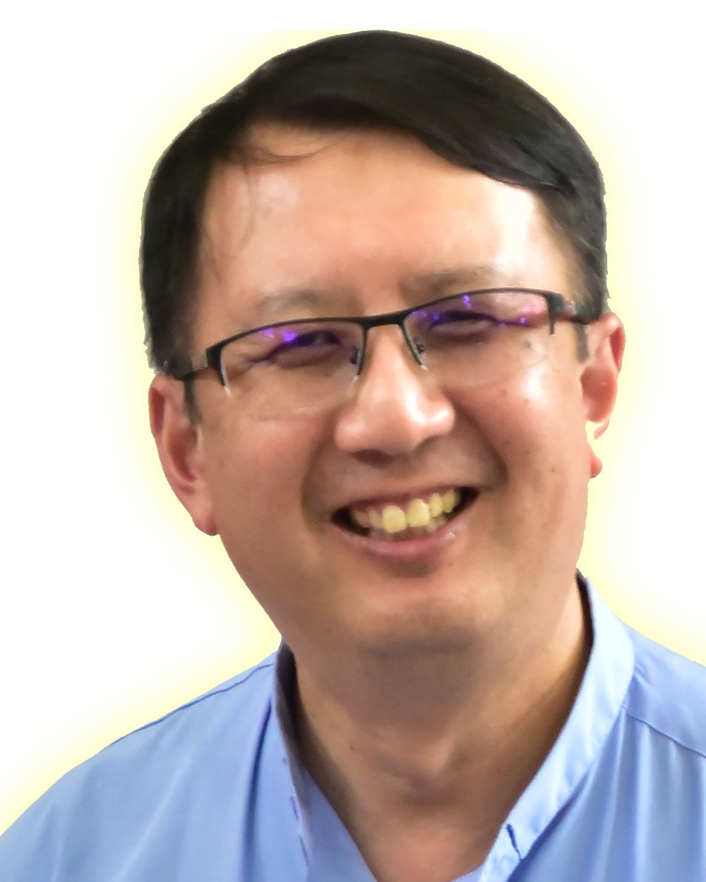 Man wearing glasses, smiling with a light blue shirt.