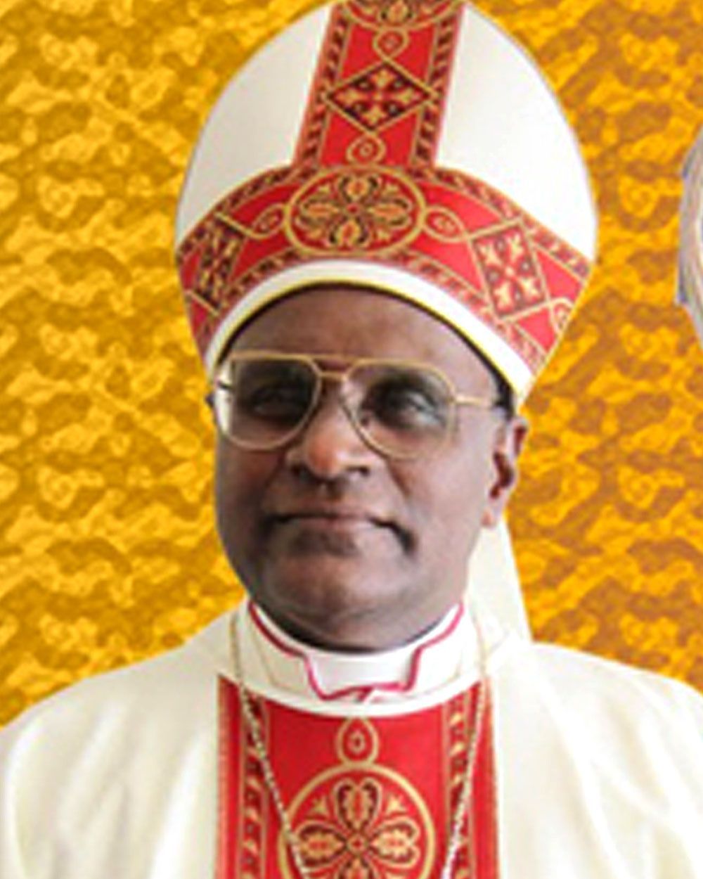 Man in religious vestments, including a mitre and stole, smiling.