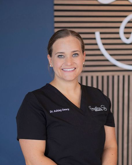 Dr. Deacy posing for a photo in black scrubs 