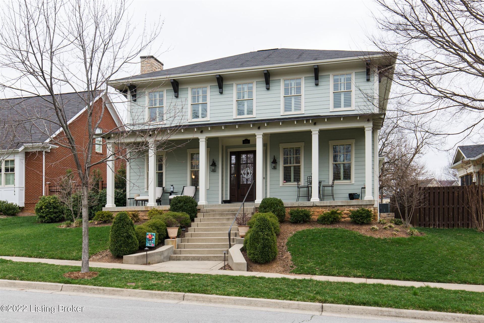 Two-story white house with front porch, steps, and landscaped yard on a quiet suburban street